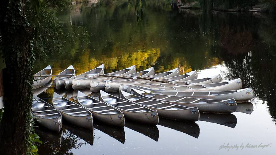 Canoes on the wye by Adrian Cooper